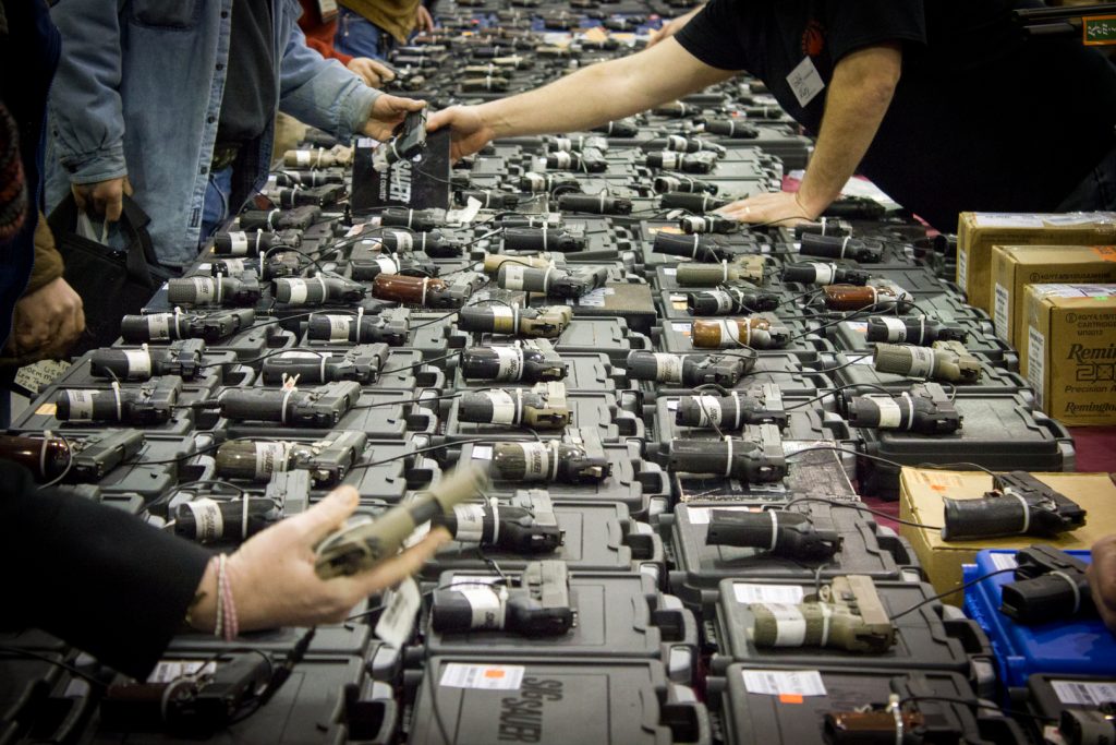 a picture of lots of handguns in a gunshow