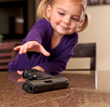 image of a young girl reaching for the gun