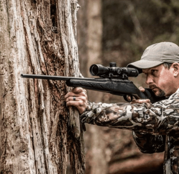 man shooting the Nightforce SHV 3-10x42mm Scope in the woods