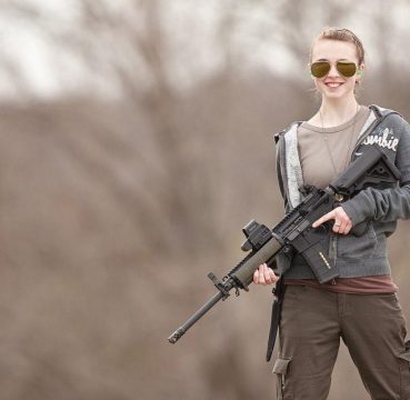 a girl pose her rifle